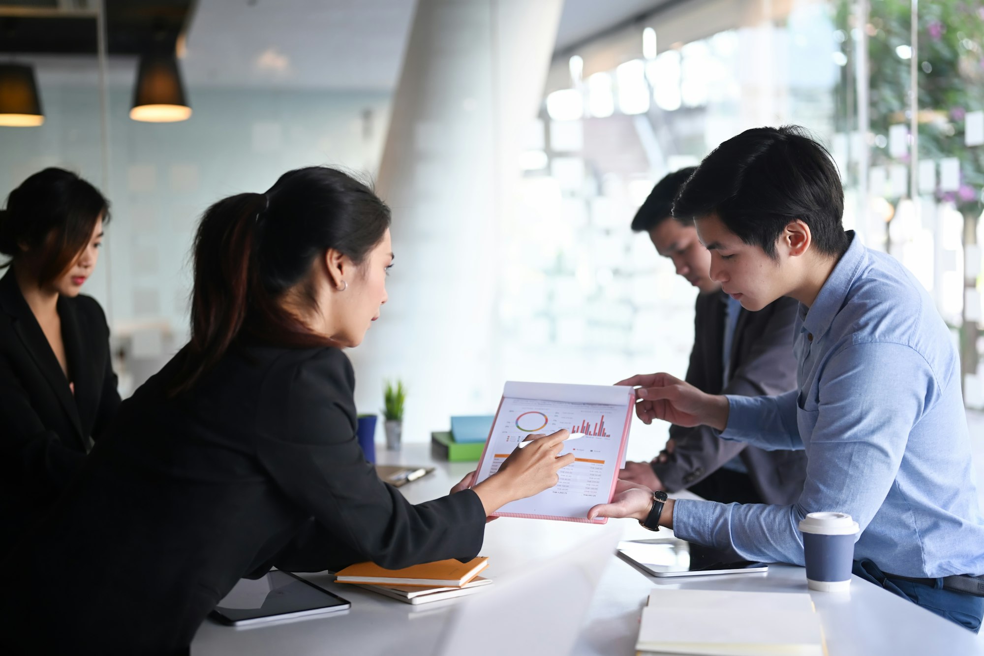 Business people analyzing documents and discussing business strategy at conference room.